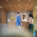 Couple talking to receptionist at hotel lobby